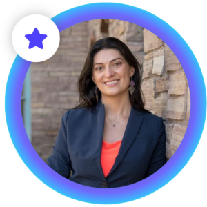 InSpace co-founder and CEO Narine Hall is shown looking at the camera and smiling confidently. She is leaning slightly against a brick while wearing a blazer and bright top. Her headshot is framed in an InSpace host circle and star. 